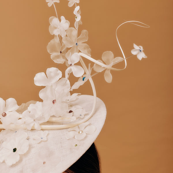 Close-up of a decorative hat with floral details on a brown background