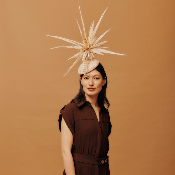 Woman wearing a decorative hat with a brown background
