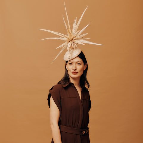 Woman wearing a decorative hat with a brown background