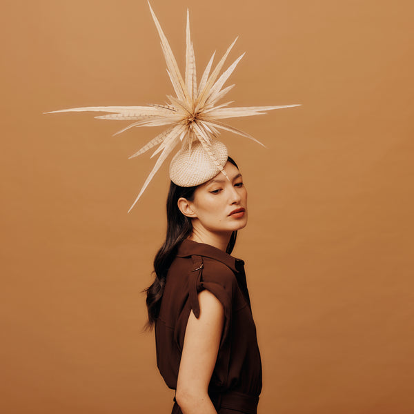 Woman wearing a decorative headpiece against a brown background