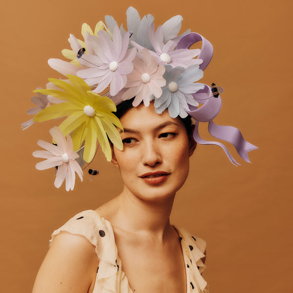 Woman wearing a colorful floral headpiece against a brown background