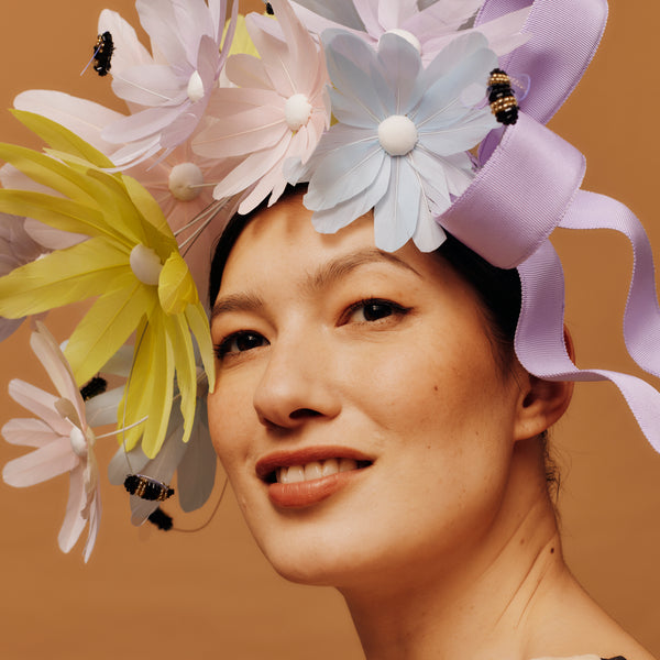 Woman wearing a colorful floral headpiece against a brown background