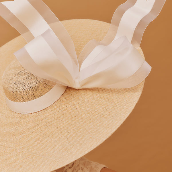 NATURAL straw hat with a decorative ribbon on a brown background