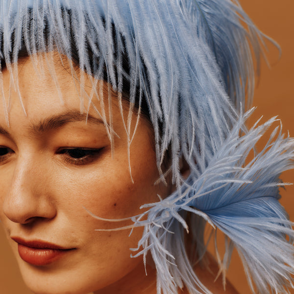 Close-up of a person with blue hat against a warm-toned background