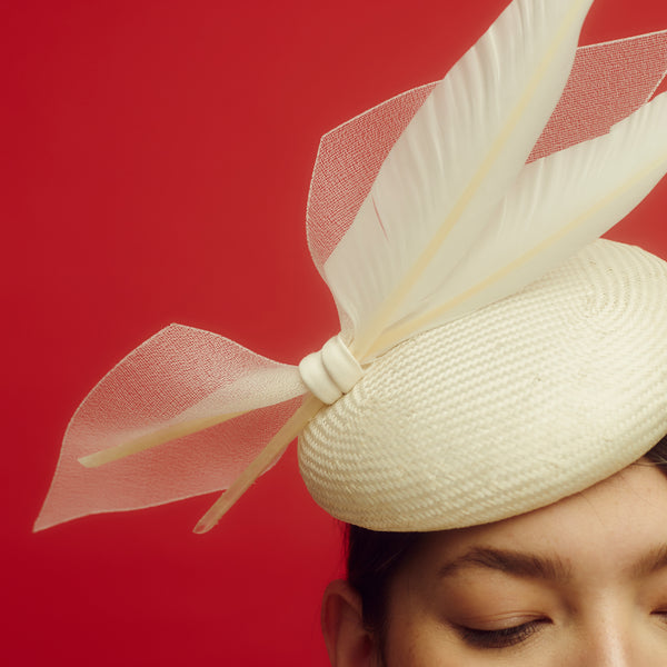 Awon Golding Ivory white straw button hat with two goose feathers and crinoline bow. Modern millinery. Close-up