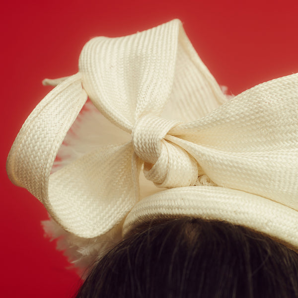 Awon Golding Ivory white straw button hat with giant ostrich pom pom and straw bow at the back. modern millinery. Close-up straw bow